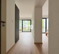 Helle Innenraum einer Zweizimmerwohnung mit Holzboden und großen Fenstern.