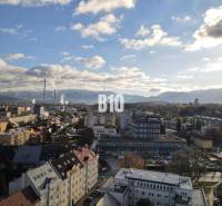Die Stadt Žilina mit Panorama, Wohnhäuser und Industriegebiet im Vordergrund.