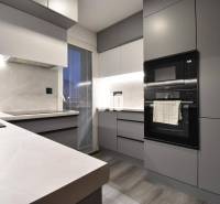 Küche in einer 4-Zimmer-Wohnung mit eingebauten Geräten und einem Boden in Holzoptik.