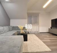 Wohnzimmer mit Ecksofa, Fernseher und Holzboden in einer 4-Zimmer-Wohnung.