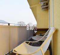 Balkon einer 4-Zimmer-Wohnung in Žilina mit Stühlen und Blick auf die Berge.