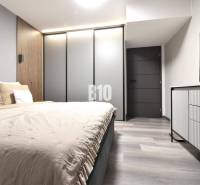 Schlafzimmer mit Holzboden und Kleiderschrank in einer 4-Zimmer-Wohnung.