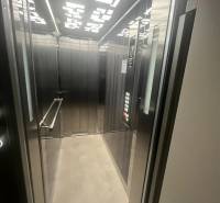 Der Aufzug in einem Gebäude mit moderner Beleuchtung und Metallpaneelen.