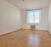 Ein leerer Raum mit einem Fenster und einem Boden in Holzoptik in einer 3-Zimmer-Wohnung.