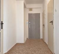 Ein Flur mit Fliesen, weiße Wände und mehrere Türen in einer 3-Zimmer-Wohnung.