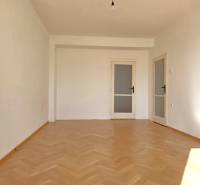 Ein Zimmer in der 3-Zimmer-Wohnung hat einen Boden mit Holzdekor und weiße Wände.