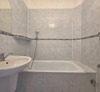 Badezimmer mit Badewanne in einer 3-Zimmer-Wohnung, gefliest mit hellen Keramikfliesen.