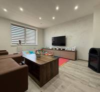 Wohnzimmer in einem Einfamilienhaus mit Sofa, Fernseher und Holzboden.