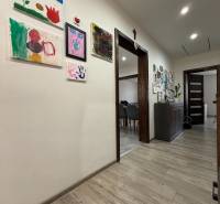 Innenraum eines Einfamilienhauses mit dekorativen Bildern an den Wänden und einem Boden mit Holzdekor.