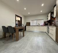 Eine Küche in hellen Farben mit eingebauten Geräten und einem Esstisch in einem Einfamilienhaus.