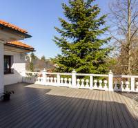 Eine Terrasse mit Holzdekor und Bäumen im Hintergrund.