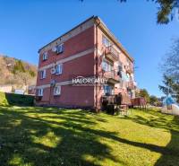Ein Wohnhaus mit einer 3-Zimmer-Wohnung in Štiavnické Bane, umgeben von grünem Rasen.
