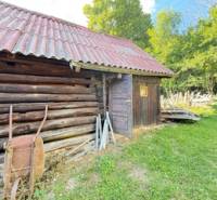 Eine Hütte in Horná Mariková aus Holz, mit einem Blechdach und einer Umgebung voller Grün.