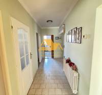 Flur in einem Einfamilienhaus mit gefliestem Boden und einfacher Wanddekoration.