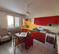 Küche mit roter Küchenzeile in einem Einfamilienhaus, ausgestattet mit Tisch und Stuhl.