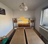 Ein Zimmer mit weißer Wand, Regalschrank und Holzboden in einem Einfamilienhaus.