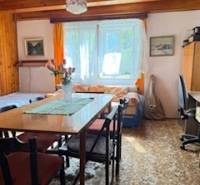 Wohnzimmer in einem Einfamilienhaus mit Esstisch und Blumen darauf.