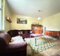 Wohnzimmer in einem Einfamilienhaus mit einem Sofa und einem Teppich auf einem Boden mit Holzdekor.