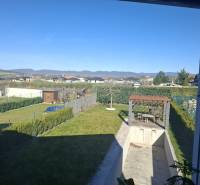 Der Garten eines Einfamilienhauses in Zvončín mit Pavillon und Pool, Blick auf die Hügel.