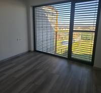 Ein Interieur in einem Einfamilienhaus mit großen Fenstern und einem Boden in Holzoptik.