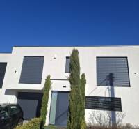 Ein Einfamilienhaus in Zvončín mit einer minimalistischen Fassade und einem gepflegten Vorgarten.