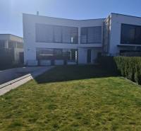 Ein Einfamilienhaus in Zvončín mit einem geräumigen Rasen und einem sonnigen Außenbereich.