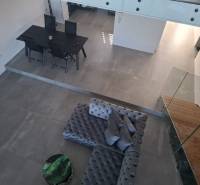 Innenraum eines Einfamilienhauses mit Blick auf den Esstisch, das Sofa und die Treppe.