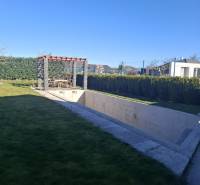 Der Garten eines Einfamilienhauses in Zvončín mit einer Pergola und einem unvollendeten Pool.