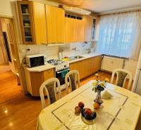 Küche in einer 3-Zimmer-Wohnung mit Holzboden und Esstisch.