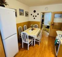 Küche in einer 3-Zimmer-Wohnung mit Esstisch und Boden mit Holzdekor.