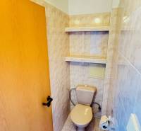 Toilette mit Keramikfliesen und Ablagefächern, Teil einer 3-Zimmer-Wohnung.