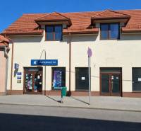 Geschäftsräume in der Obchodná-Straße in Krupina mit schrägem Dach und Schaufenstern.
