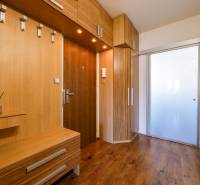 Eingangsflur in einer 3-Zimmer-Wohnung mit Holzboden und Einbaumöbeln.