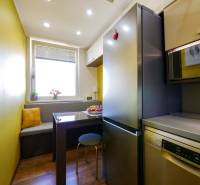 Küche in einer 3-Zimmer-Wohnung mit Holzboden, Essbereich mit Bank.