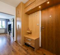 Innenraum einer 3-Zimmer-Wohnung mit Flur, Holzschränken und einem Boden mit Holzdekor.