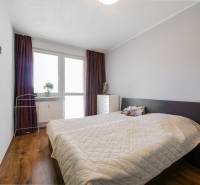Schlafzimmer in einer 3-Zimmer-Wohnung mit Holzboden und Bett.