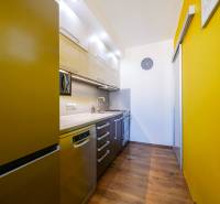 Küche in einer 3-Zimmer-Wohnung mit einer farbigen Wand und einem Boden in Holzoptik.