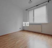 Ein leerer Raum mit Wänden in einer 3-Zimmer-Wohnung, Holzboden, großes Fenster.