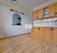 Küche in einer 3-Zimmer-Wohnung mit Holzboden und Einbauschränken.