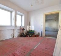 Ein Zimmer in einem Einfamilienhaus mit rotem Boden und Fenstern, Bytča.