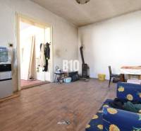 Ein Zimmer in einem Einfamilienhaus mit einem Holzboden, einem Ofen und Möbeln mit Blumenstoff.