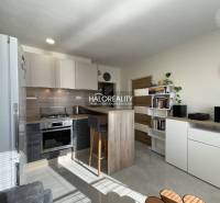 Küche in einer Einzimmerwohnung mit hellem Interieur und einer Theke zum Sitzen.