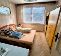 Schlafzimmer in einer 3-Zimmer-Wohnung mit Bett, Schrank und Boden in Holzoptik.