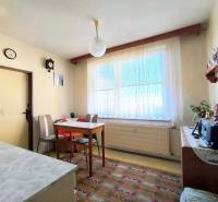 Esszimmer mit einfachen Möbeln in einer 3-Zimmer-Wohnung, Boden mit dekorativem Teppich.