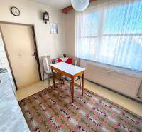 Küche in einer 3-Zimmer-Wohnung mit Esstisch, Stühlen und Teppich.