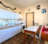 Küche in einer 3-Zimmer-Wohnung mit weißen Schränken und dekorativen Fliesen.