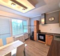 Küche in einer 3-Zimmer-Wohnung mit Holzboden und Esstisch.