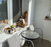 Ein Balkon mit Dekorationen und einem Tisch in einer 2-Zimmer-Wohnung bietet eine angenehme Sitzgelegenheit.