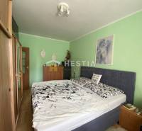Schlafzimmer in einer 2-Zimmer-Wohnung mit Bett und Möbeln, die Wände sind hellgrün.
