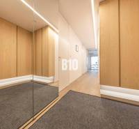 Flur in einer 3-Zimmer-Wohnung mit Holzboden und Spiegel.